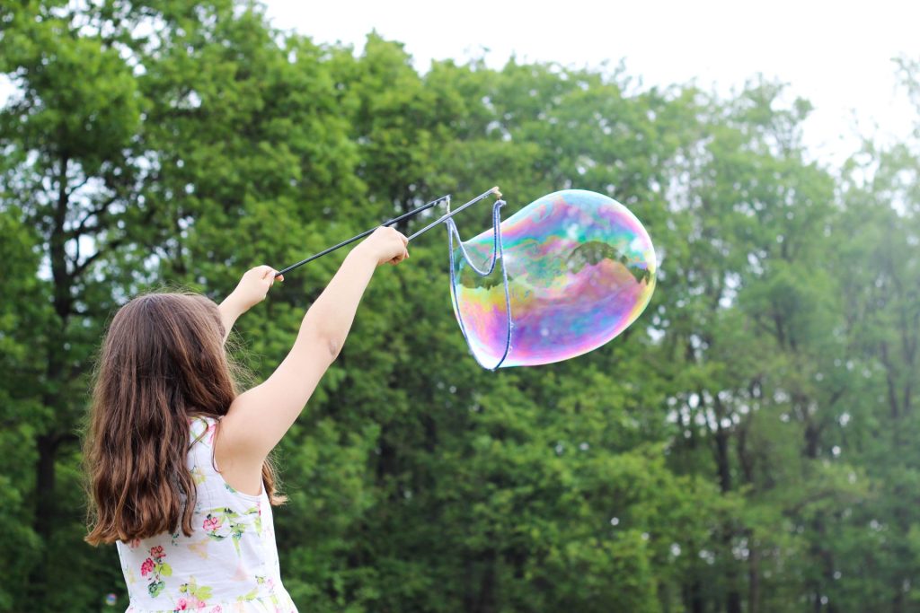 A child playing with bubbles outside